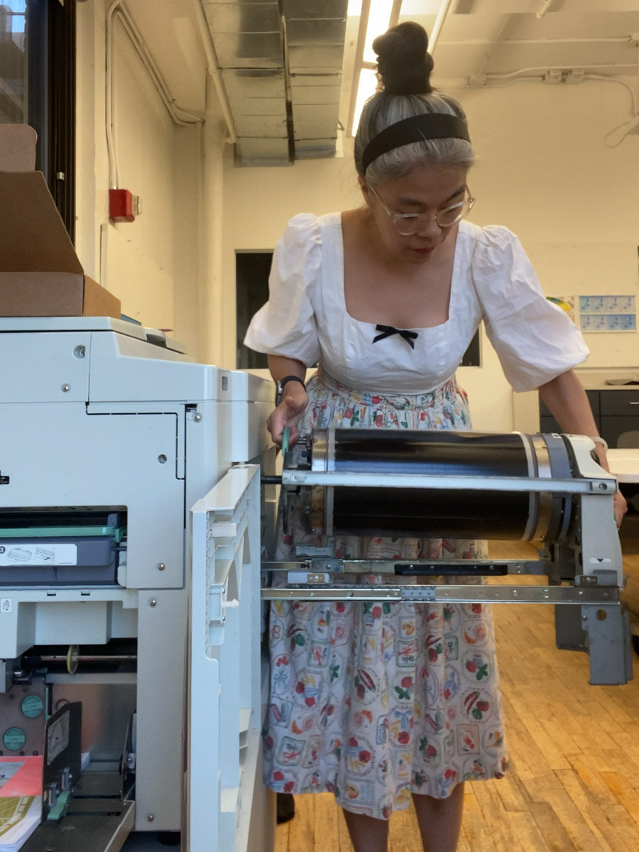 Winnie Cheng of Oh So Nice Design Co swapping out a risograph color drum during a printing session in the Risolab